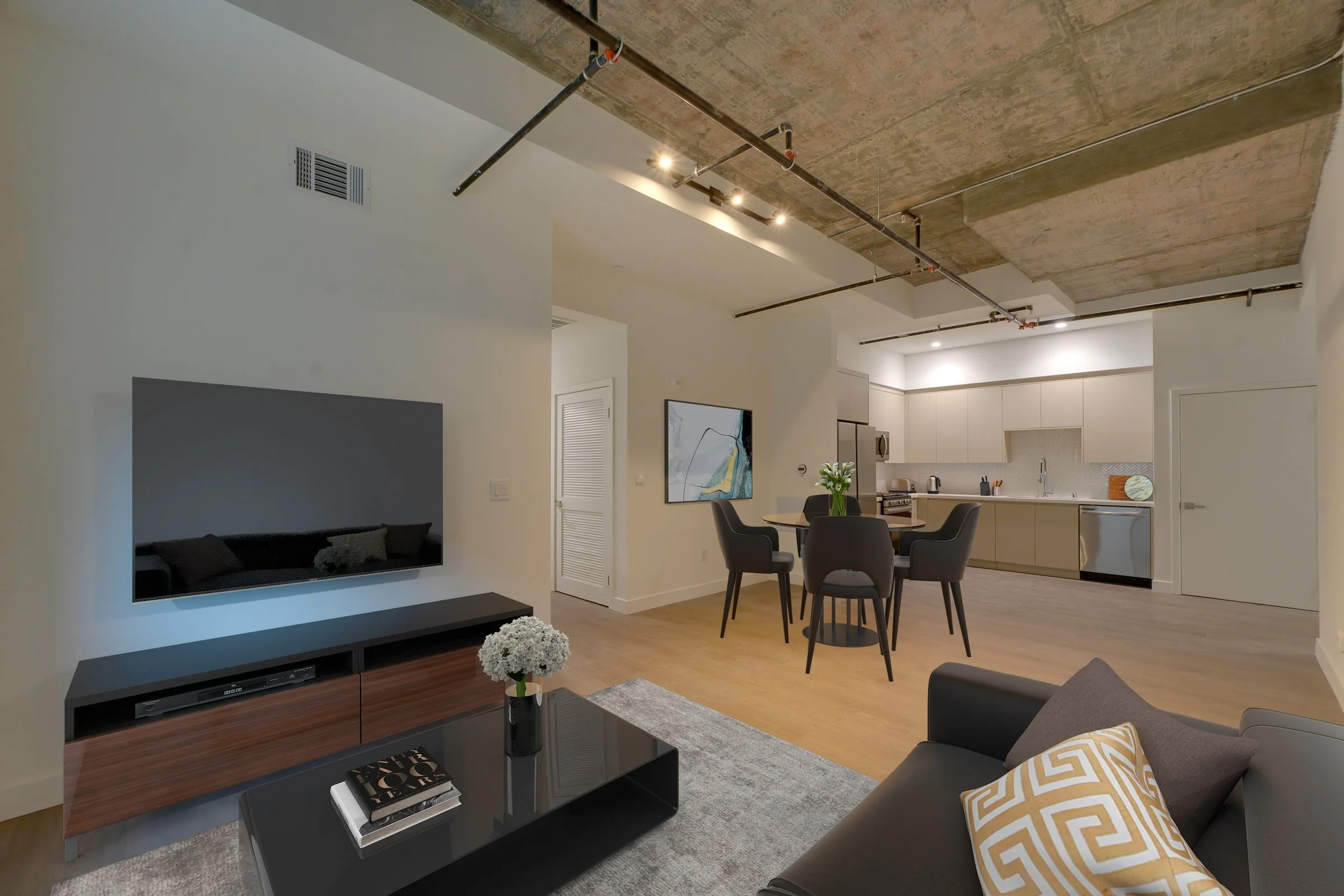 Pine on Gramercy living and dining room with exposed concrete ceiling